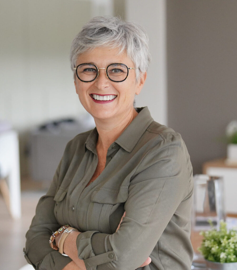An image of a smiling mature woman with white hair after dental treatment at Clearly Dental Camden